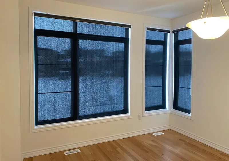 Solar-screen roller shades on black-framed windows