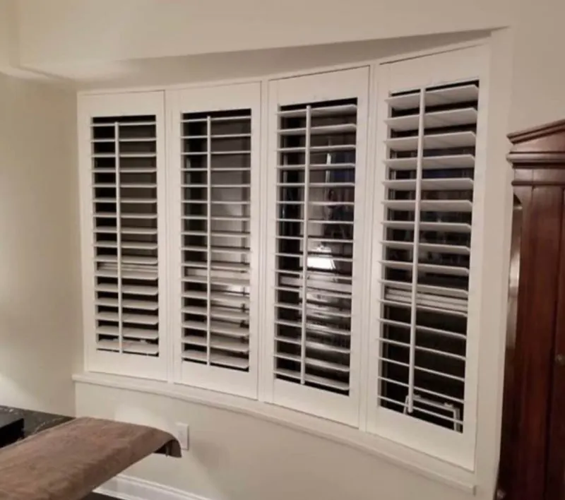 Four shutter panels across a curved window