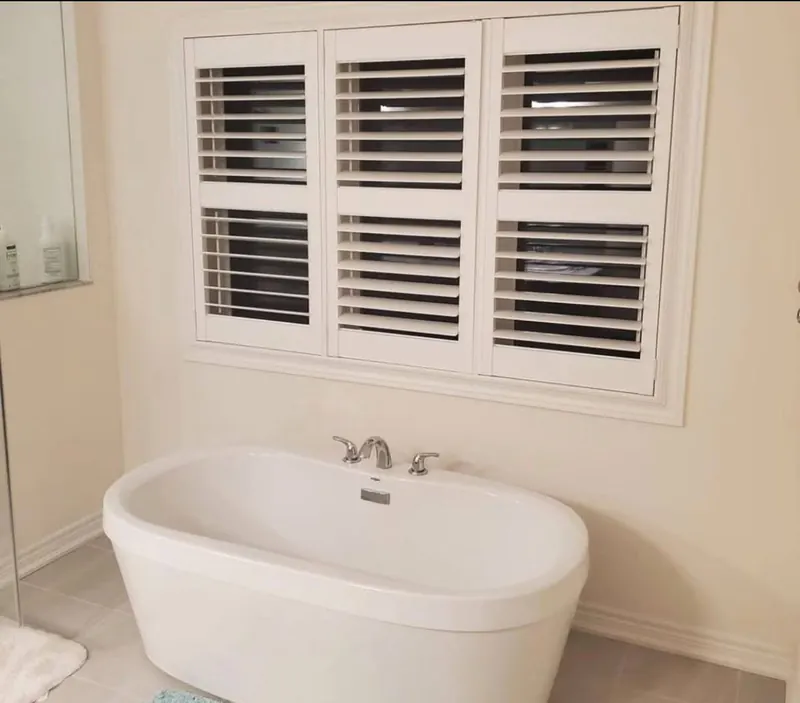 Shutters above a freestanding bathtub