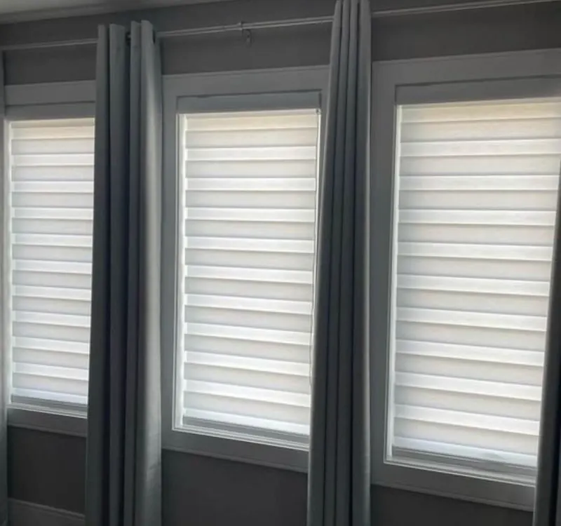 White zebra blinds between grey curtains
