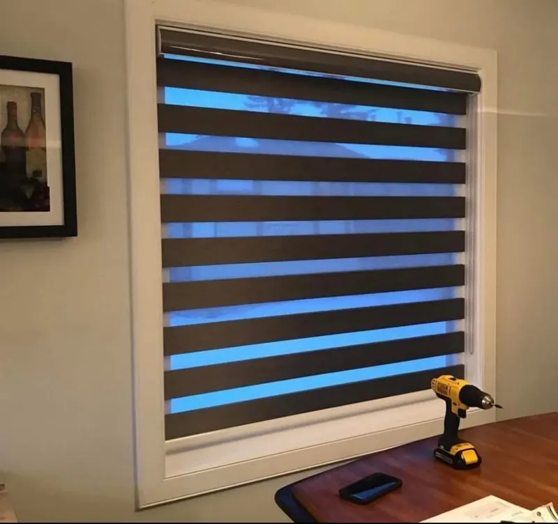 A dark zebra blind with sheer bands open