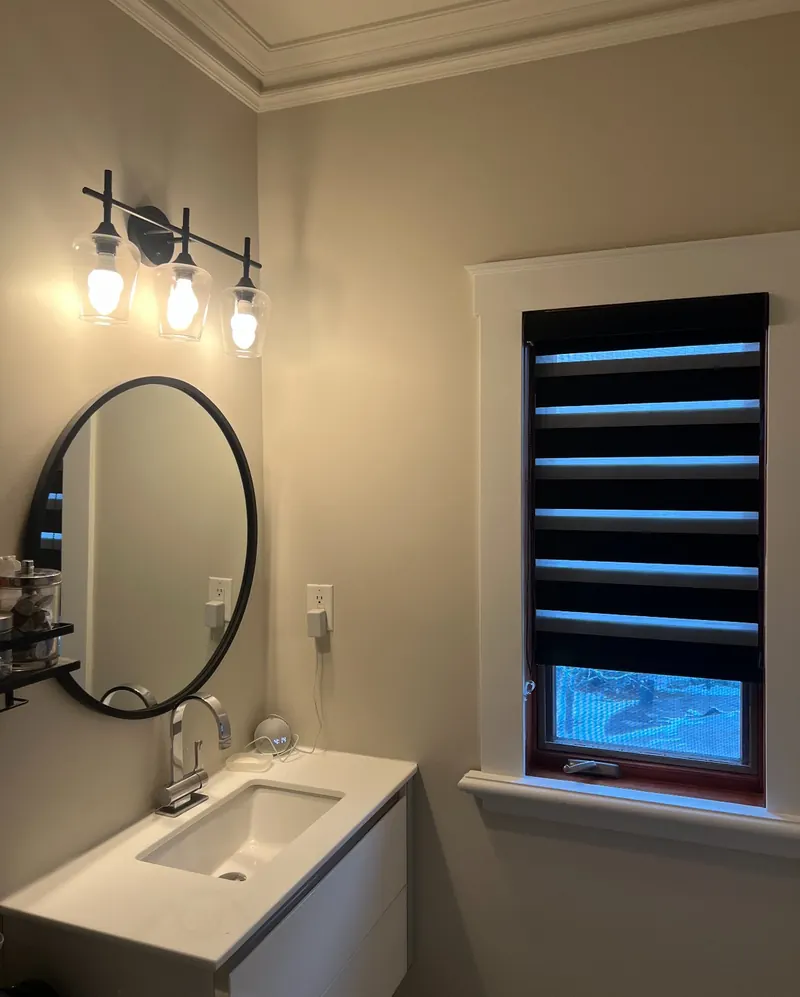 A black zebra blind in a powder room